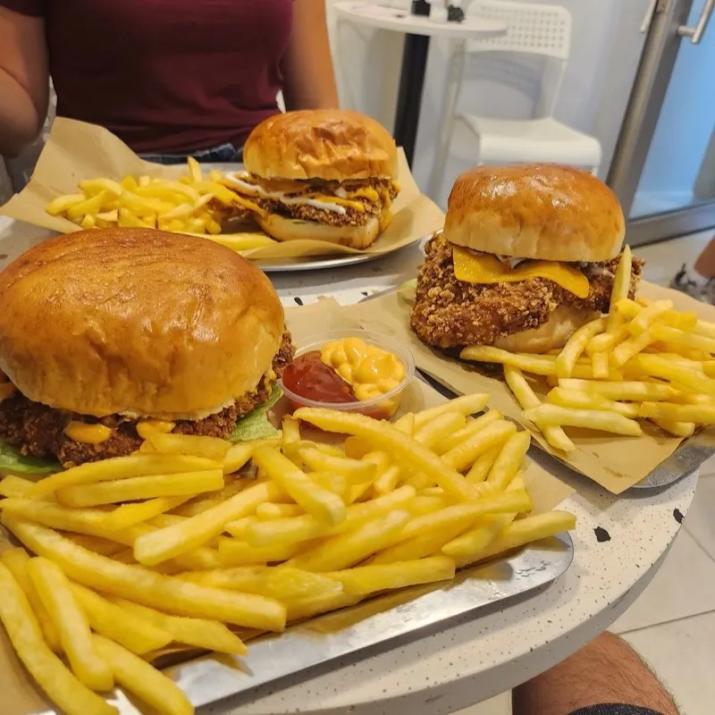 Burgers and fries on a table at Takagu Fried Chicken